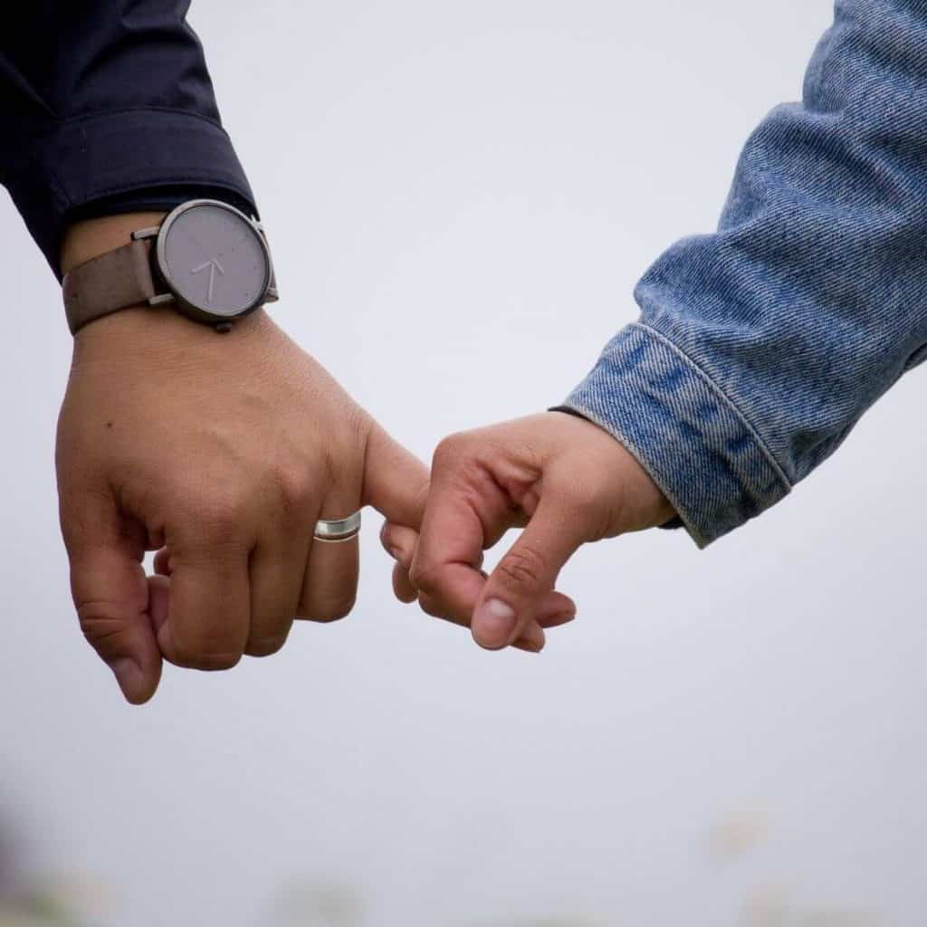 Coppia che si tiene per mano, uomo che indossa l'anello