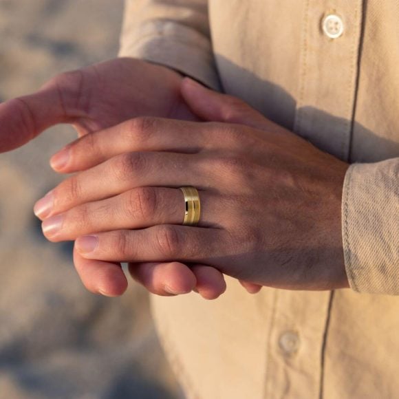 Valour – Anello in tungsteno dorato per uomo L'uomo indossa un'alleanza in tungsteno dorato.