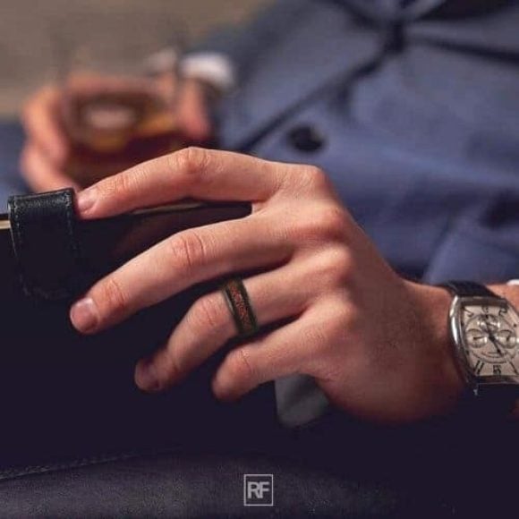 Uomo che indossa un anello di tungsteno nero e rosso