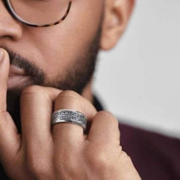 Uomo che indossa un anello in tungsteno d'argento con motivo a nodo celtico