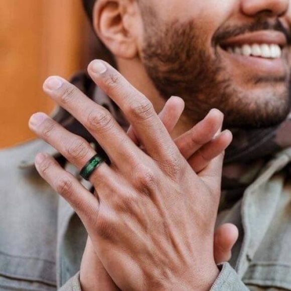 Uomo che indossa un anello di tungsteno nero e verde
