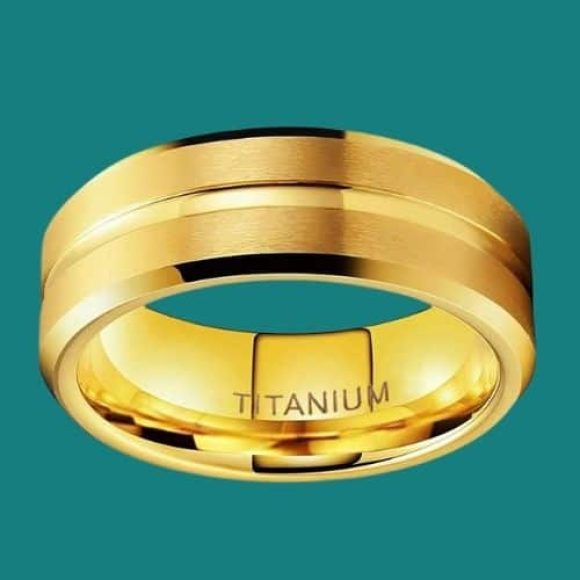 Anello in titanio oro per uomo su sfondo verde acqua