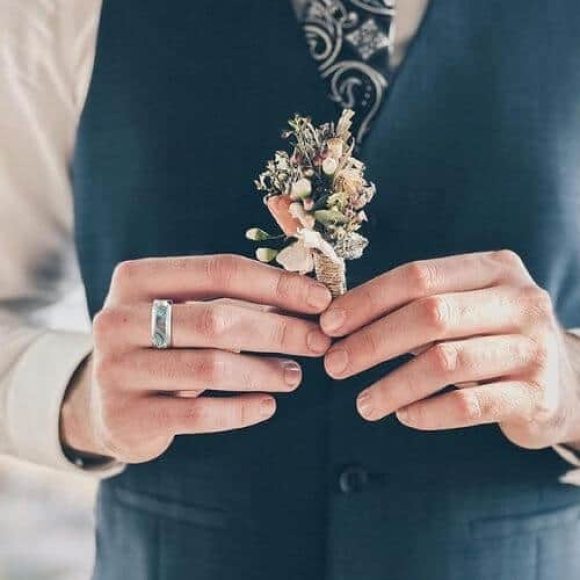L'uomo prova la sua conchiglia di abalone e l'anello di titanio